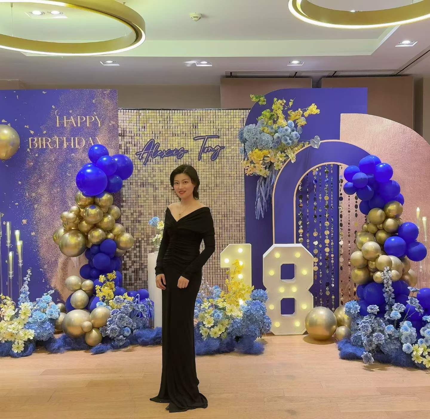 18th birthday celebration with blue and gold balloon arch and sequin backdrop