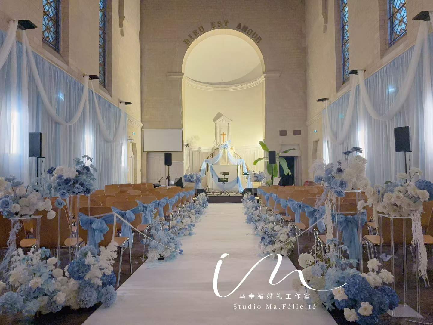 Church ceremony aisle with dusty-blue ribbons and hydrangea chair decor