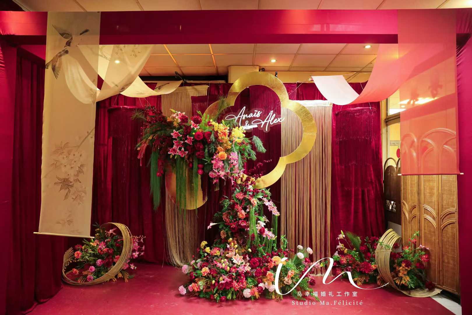 Gold quatrefoil frame backdrop with cascading red and orange florals