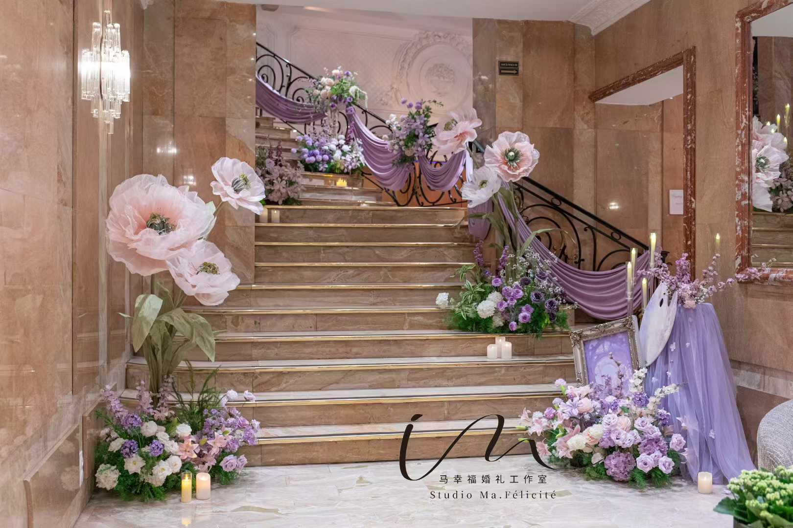 Lilac-draped staircase with oversized paper flowers and candlelight