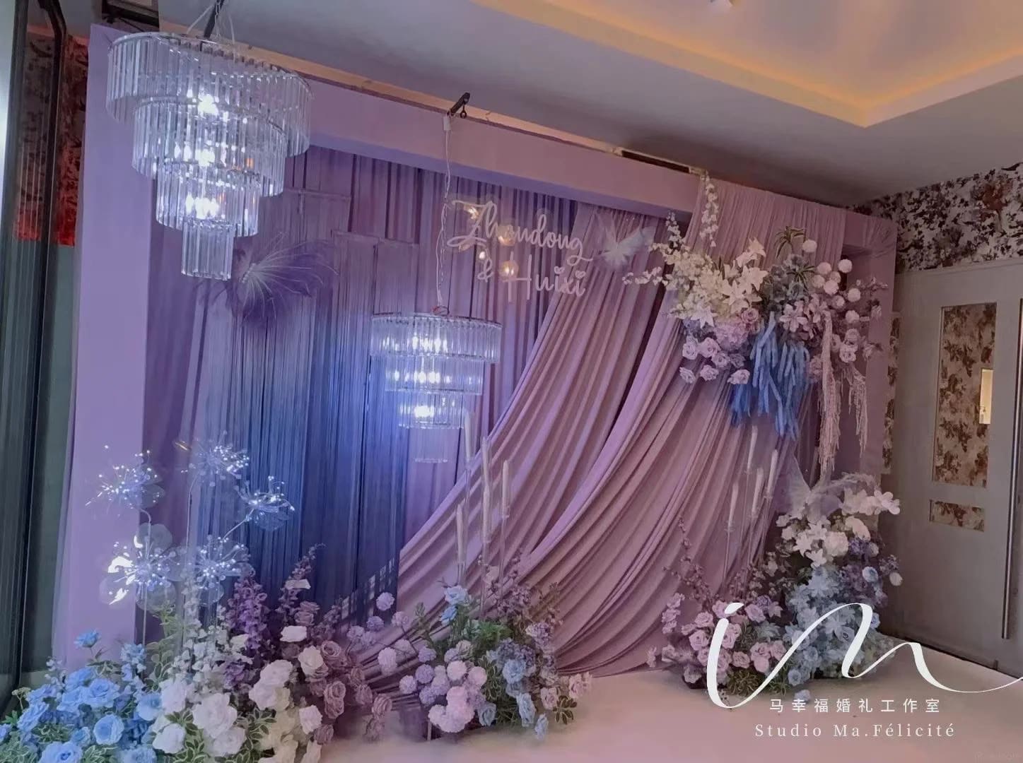 Purple and lilac wedding backdrop with crystal chandeliers