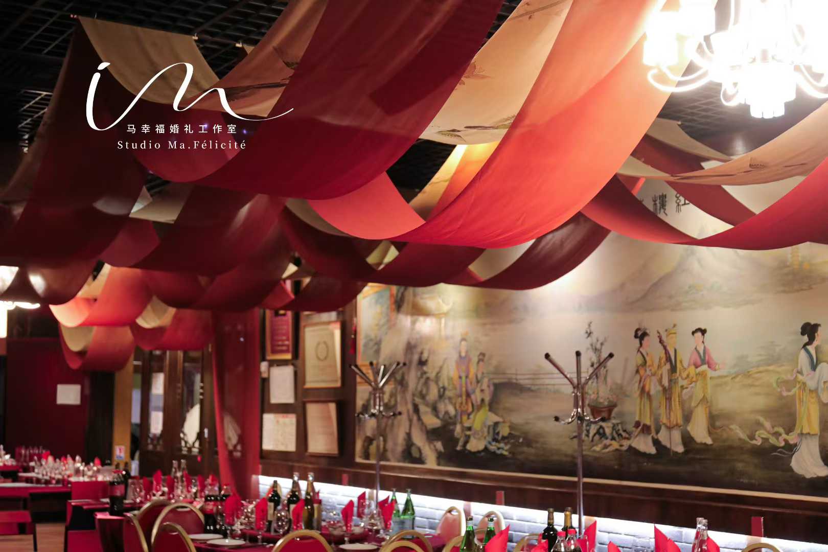 Draped scarlet silk ceiling canopy over a traditional Chinese mural backdrop